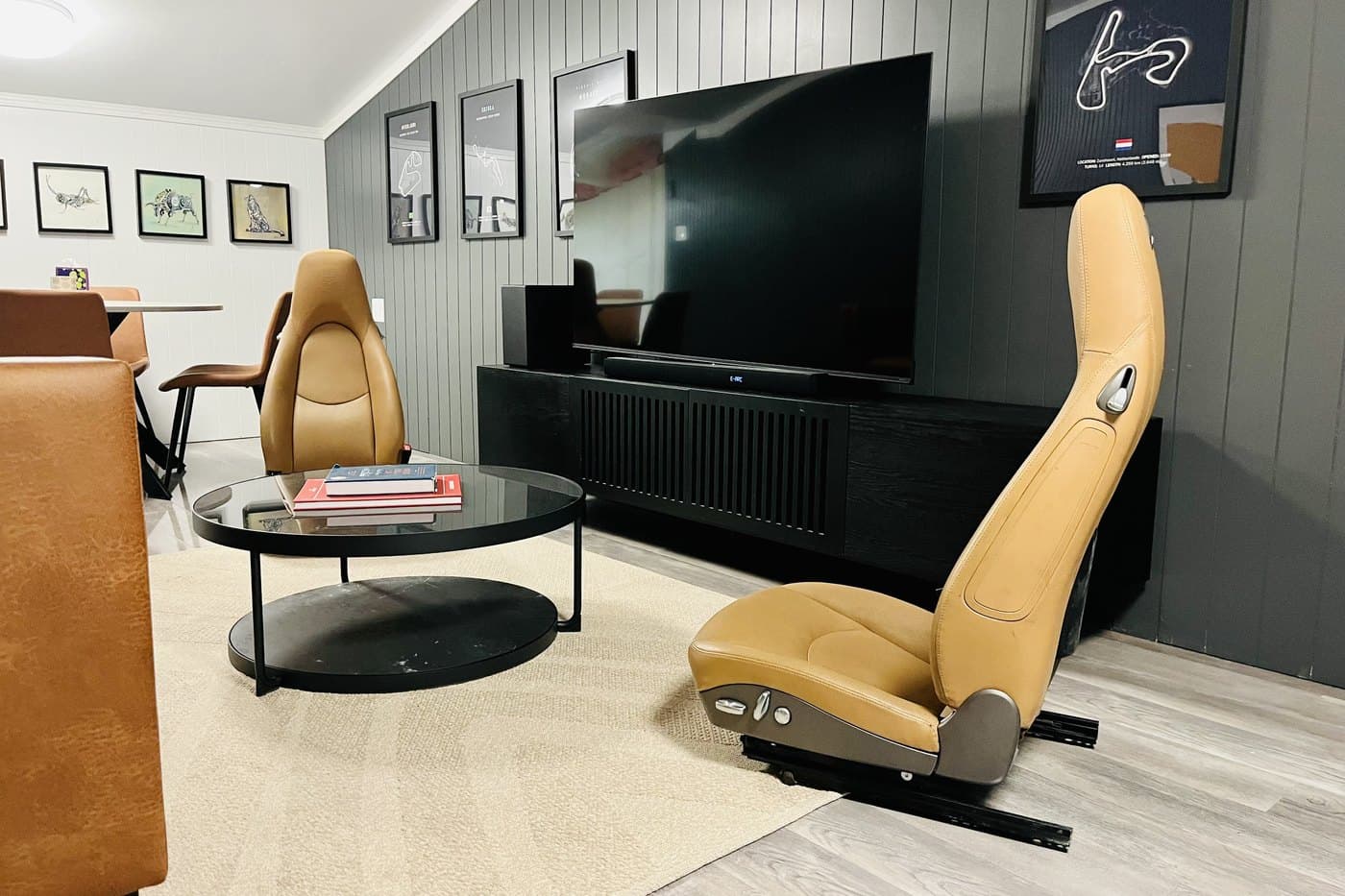 Seats from a Porsche facing a large screen in Senna's Lounge, where drivers review their footage between sessions