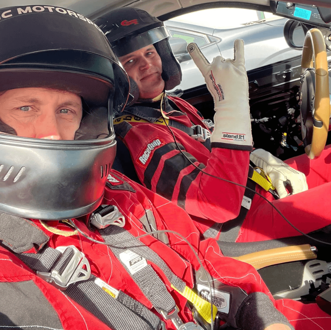 Jon-Eric coaching a student one-on-one — both helmeted, in the car