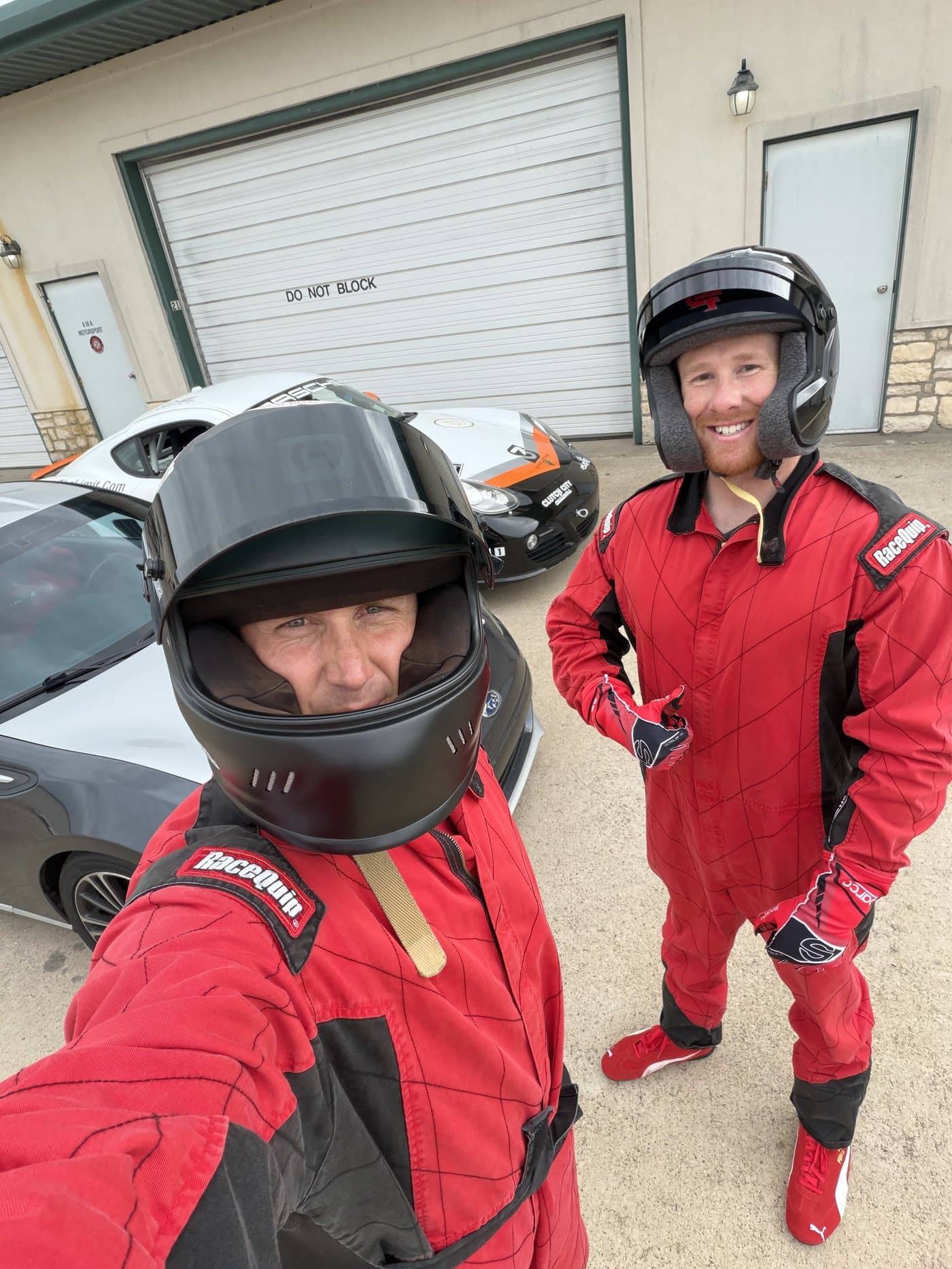 Two drivers in race suits and helmets before a session at Motorsport Ranch Cresson