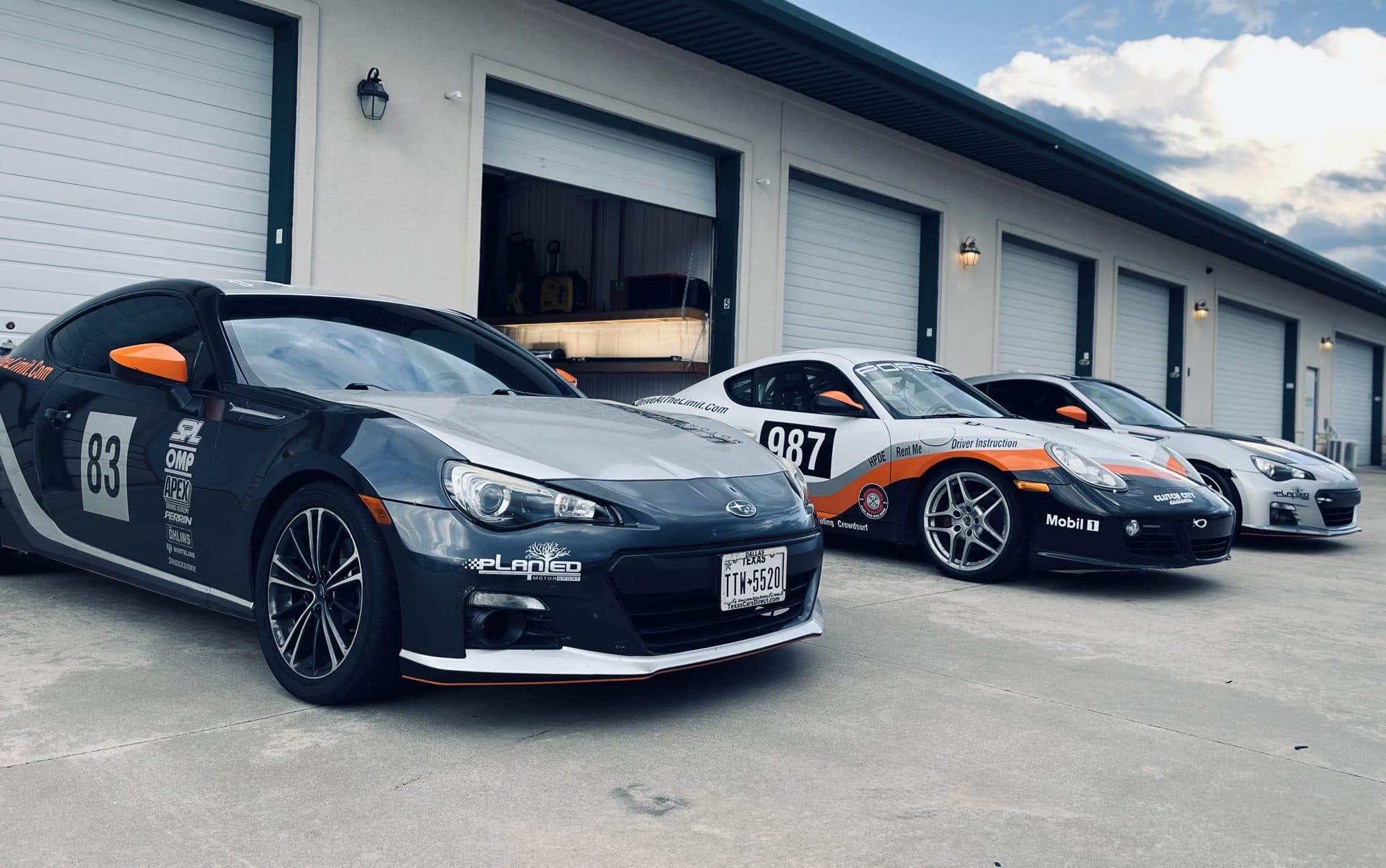 Race-prepped cars lined up in the paddock at Motorsport Ranch Cresson