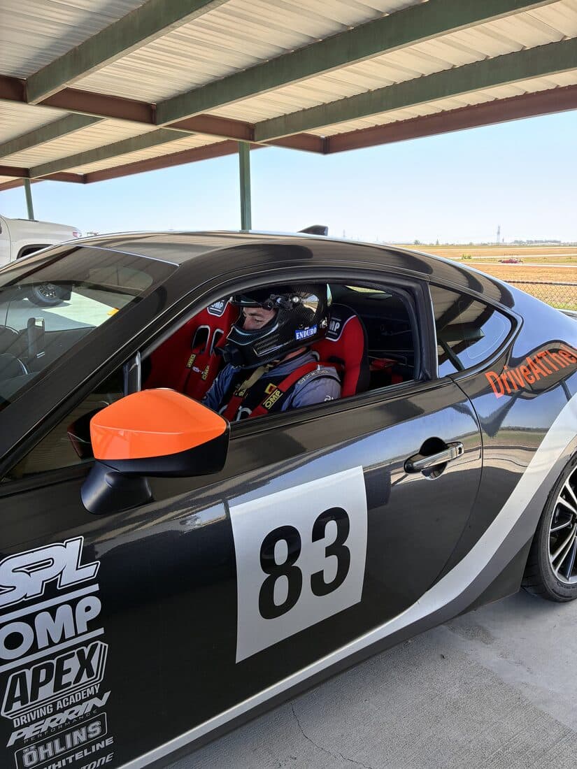 A driver belted into the BRZ, helmet on, waiting to go out