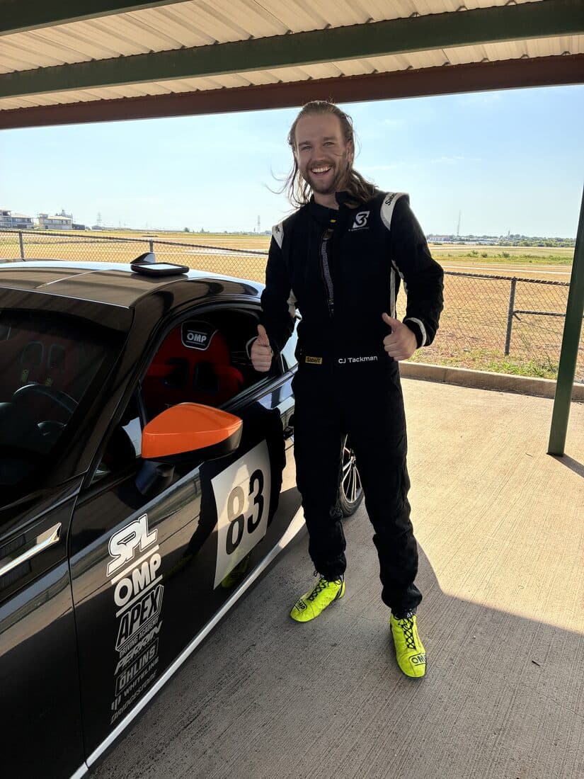 A driver in a race suit beside the BRZ before his session