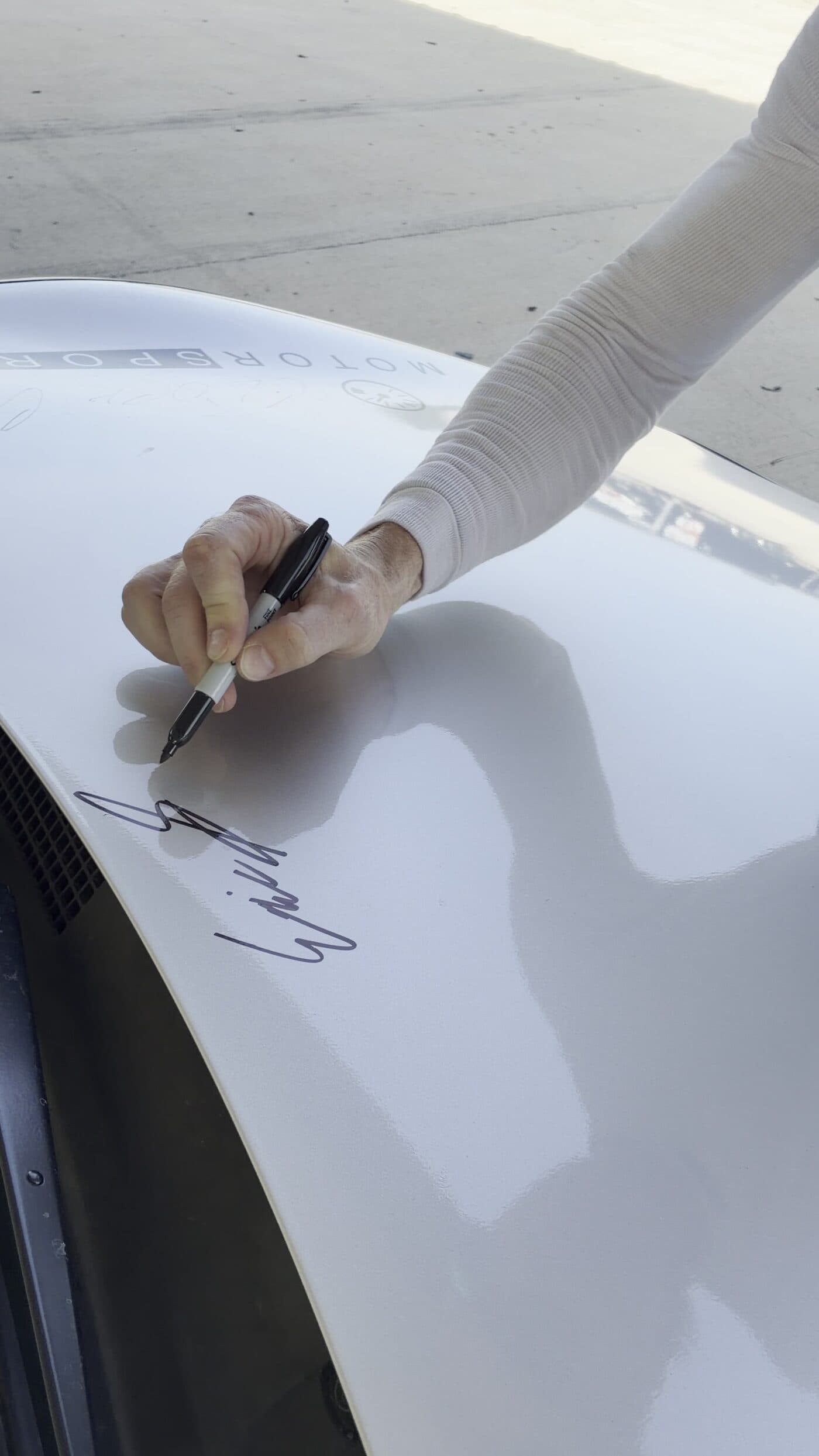 A driver signing his name on the bonnet of the BRZ